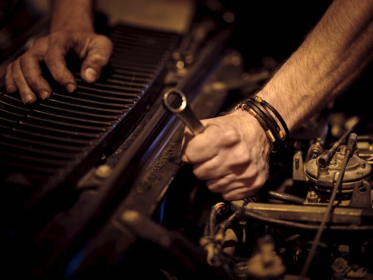 A skilled mechanic using advanced diagnostic tools to inspect a vehicle's complex electronic system in a clean garage.